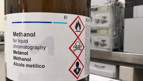 Image of a large container of Methanol with an example of GHS labeling in use